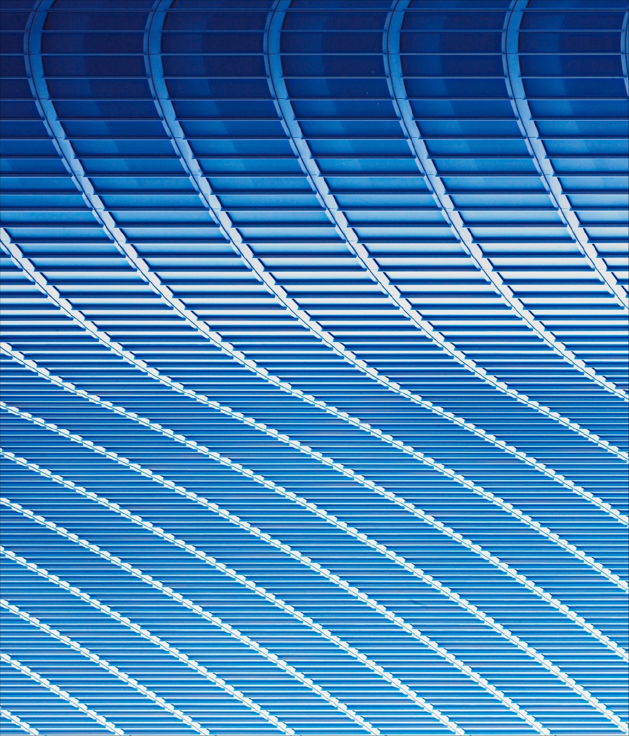 Photo of the curved surface of a blue-tiled office roof.