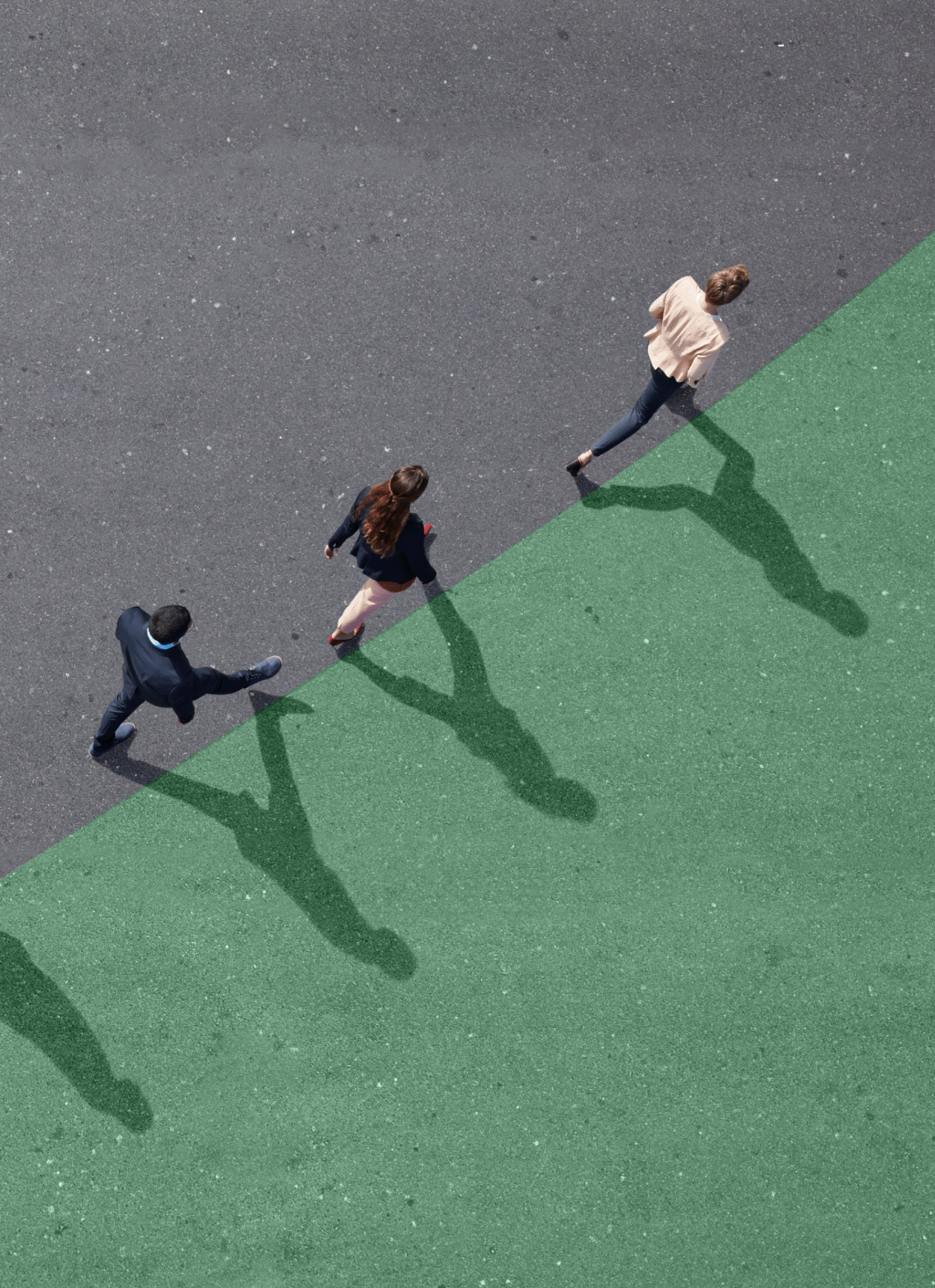 OT-photo-group-walking-diagonally Group of professionals walking diagonally along a green painted section of a basketball court.