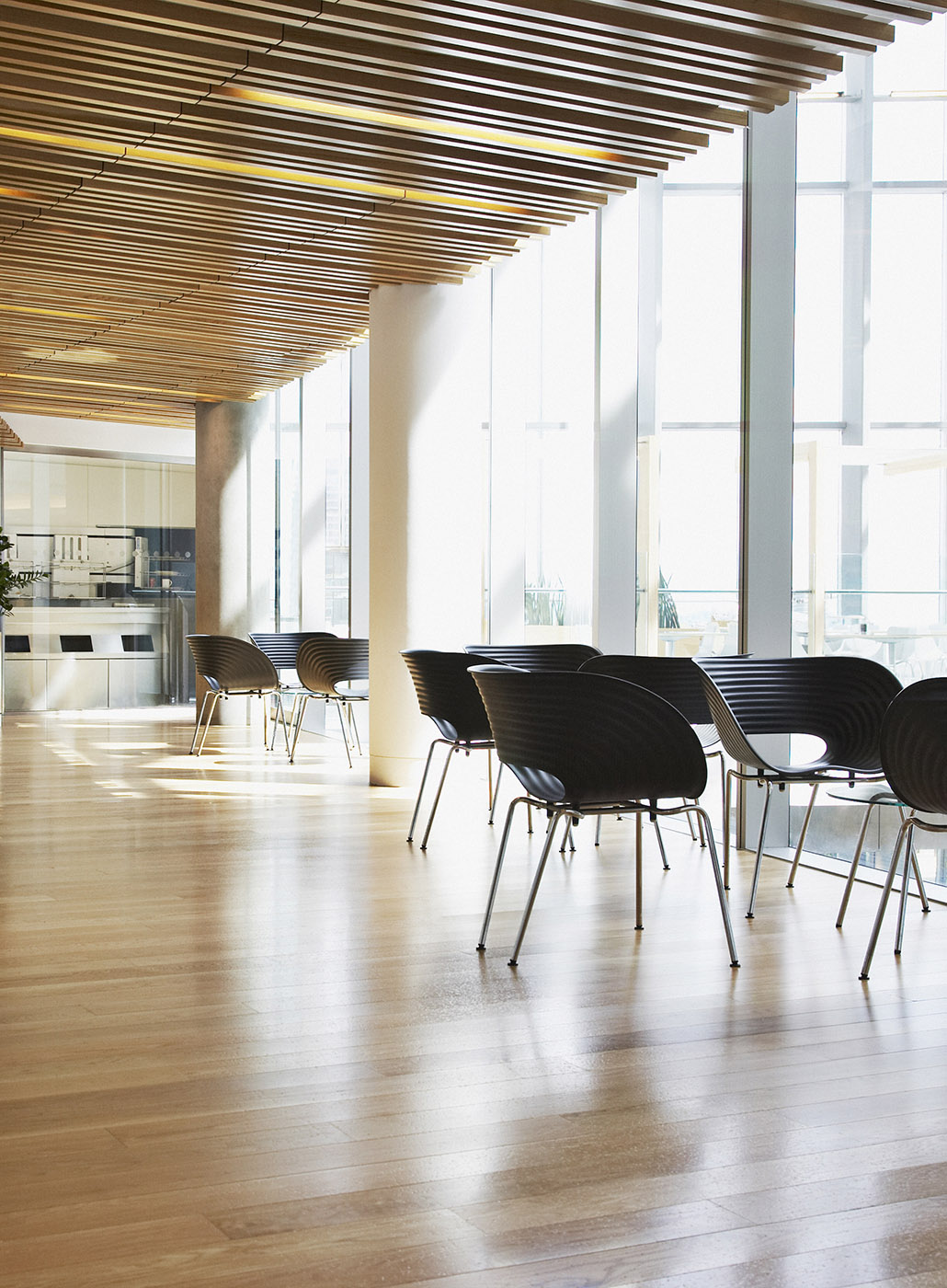 Foto de cadeiras dispostas em um espaço de trabalho moderno e bem iluminado com piso de madeira